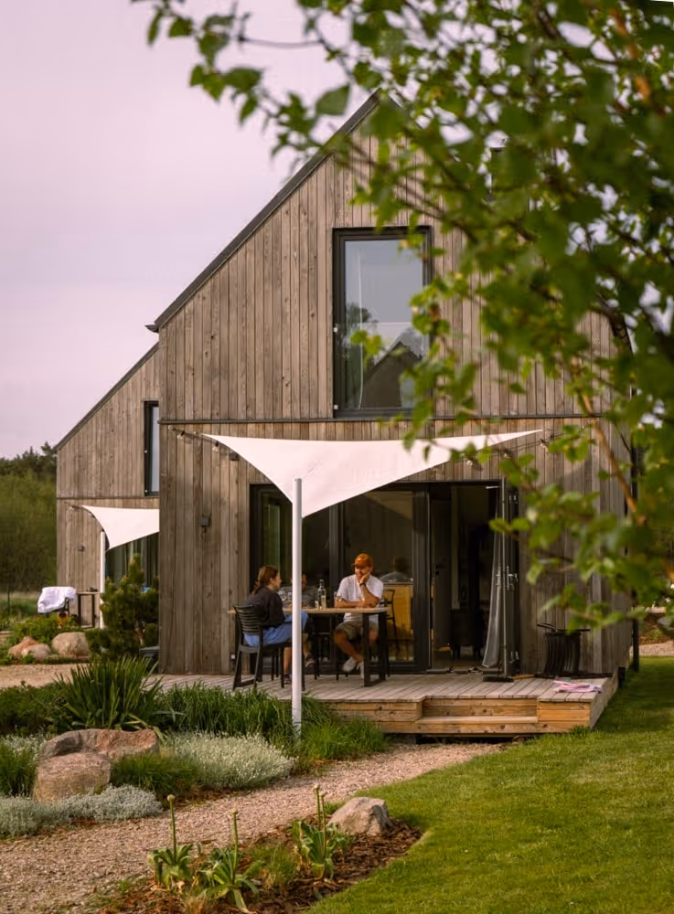 A couple of people sitting at a table outside of a house